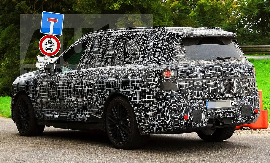 BMW iX7 (2027) Blick von schräg hinten auf den fahrenden BMW iX7 (2027).