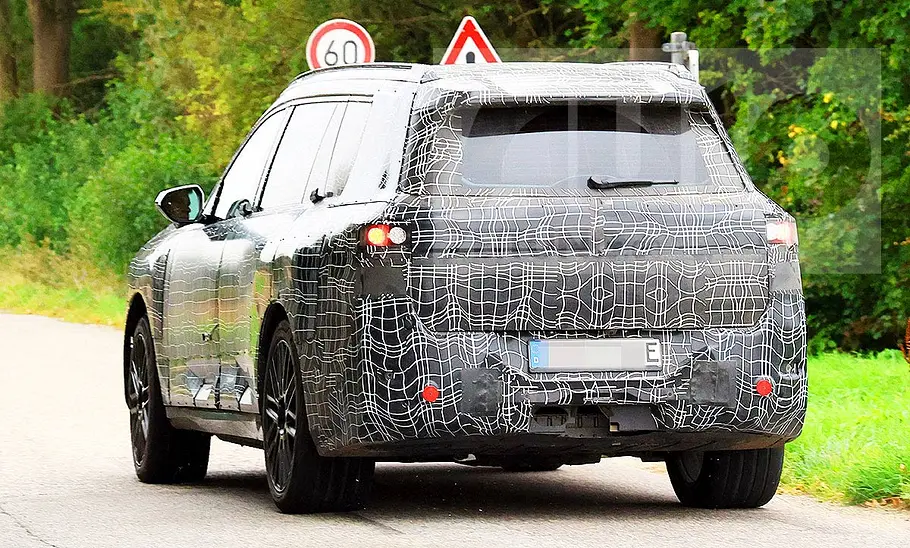 BMW iX7 (2027) Blick von hinten auf den fahrenden BMW iX7 (2027).