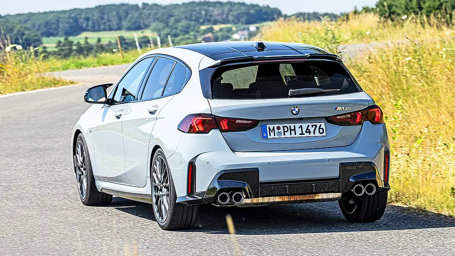 Blick von schräg hinten auf den fahrenden BMW M135 xDrive. 