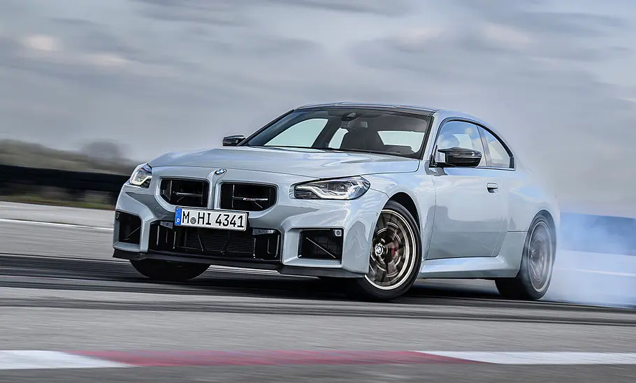 BMW M2 CS (2025) Der BMW M2 CS (2025) fahrend auf einer Rennstrecke von schräg vorne.
