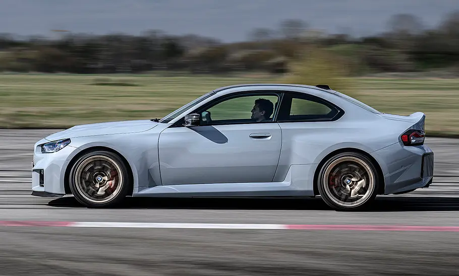 BMW M2 CS (2025) Der BMW M2 CS (2025) fahrend auf einer Rennstrecke in der Seitenansicht.
