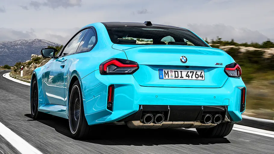 Blick von schräg hinten auf den fahrenden BMW M2 xDrive.