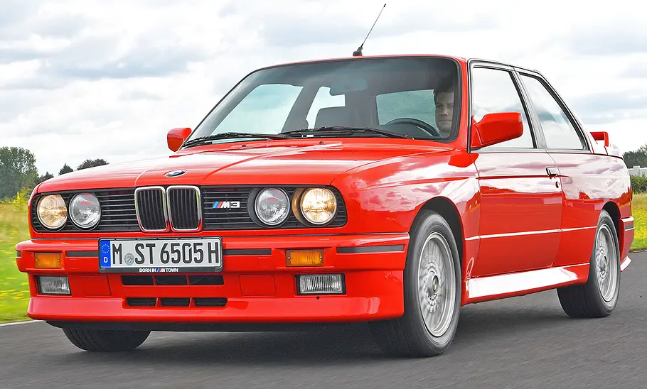 BMW M3 (E30) Der BMW M3 (E30) fahrend von vorne.