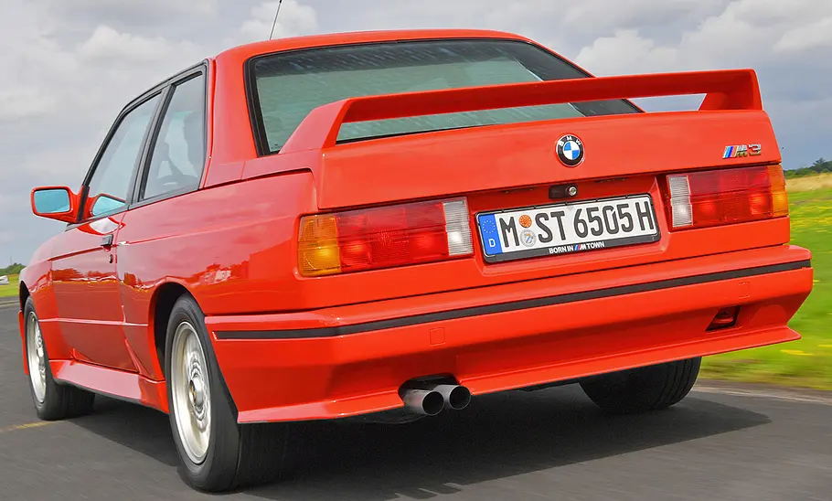 BMW M3 (E30) Der BMW M3 (E30) fahrend von hinten.