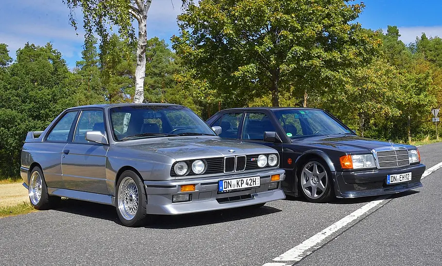 Der BMW M3 E30 und Mercedes 190 Evo statisch von schräg vorne fotografiert.