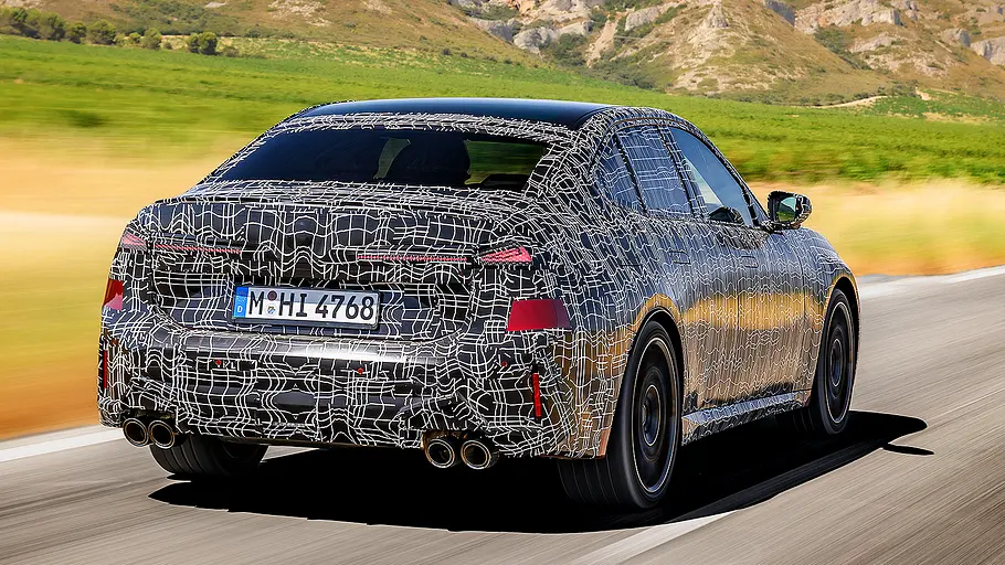 BMW M350 xDrive (2027) Blick von schräg hinten auf den fahrenden BMW M350 xDrive (2027).