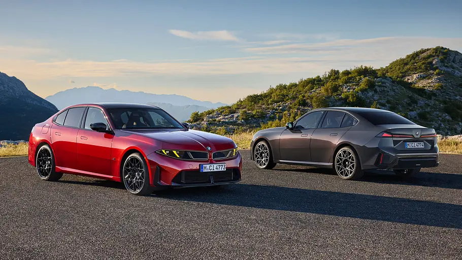 BMW M350 xDrive und 320 Ein BMW M350 xDrive in Vorderansicht und ein grauer BMW 320 in Heckansicht vor einer Berglandschaft.