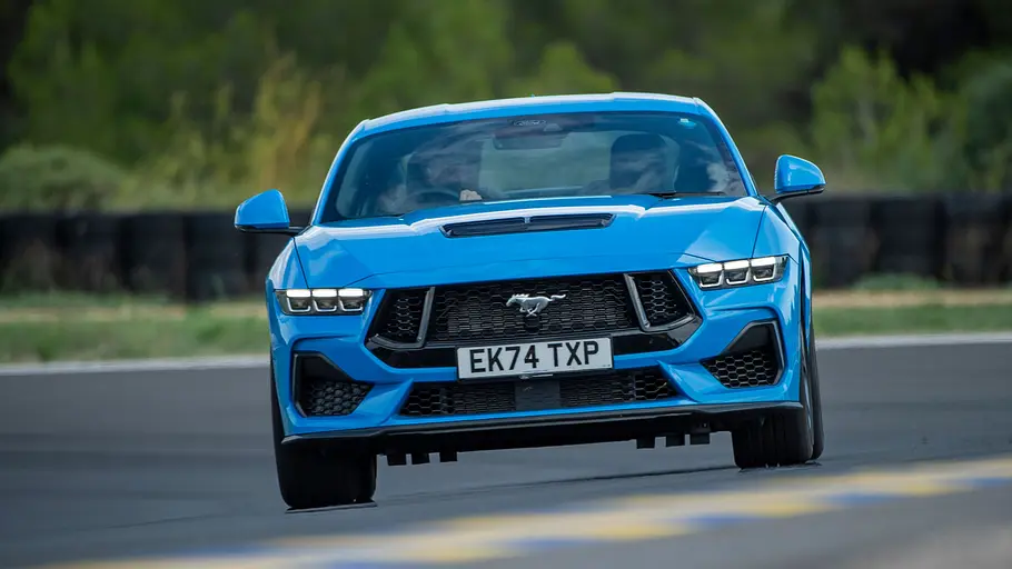 Der Ford Mustang GT fährt auf einer Rennstrecke, von vorne fotografiert.