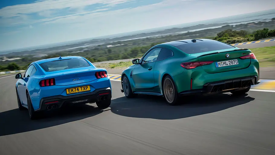Ford Mustang GT und BMW M4 CS fahren nebeneinander auf einer Rennstrecke, von hinten fotografiert.
