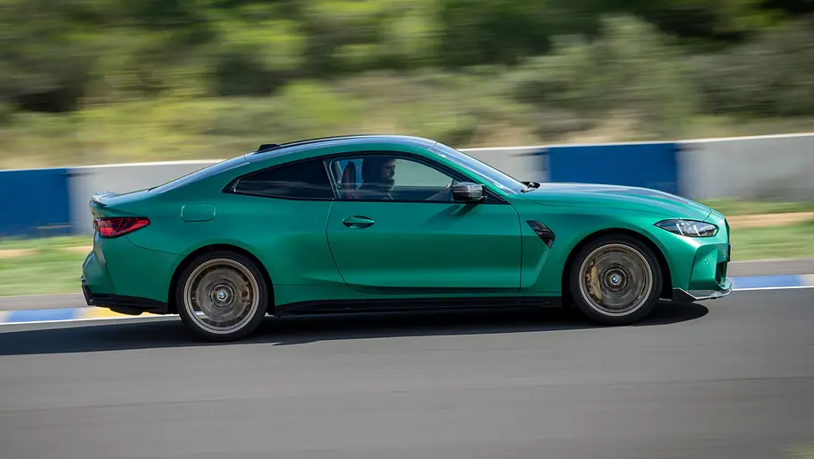 Der BMW M4 CS fährt auf einer Rennstrecke, von rechts fotografiert.