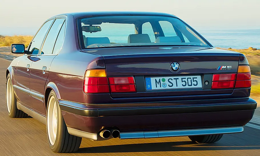 Der BMW M5 (E34) fahrend von schräg hinten