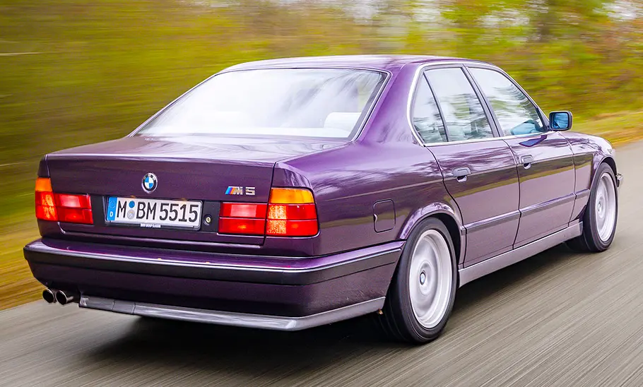 Der BMW M5 (E34) fahrend von schräg hinten fotografiert.