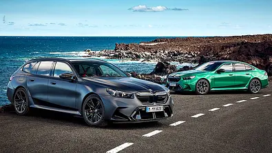 Der BMW M5 (2024) als Touring (vorne) und Limousine (hinten), stehend, fotografiert von schräg vorne. - Foto: BMW
