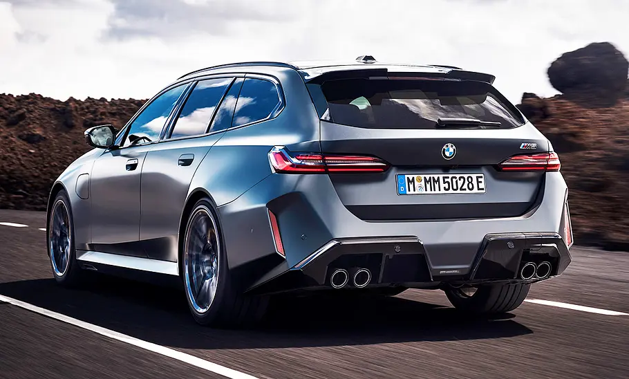 Der BMW M5 Touring (2024) fahrend; fotografiert von schräg hinten.