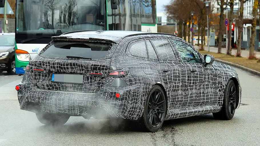 Blick von schräg hinten auf den fahrenden Erlkönig des BMW M5 Touring Facelift (2027).