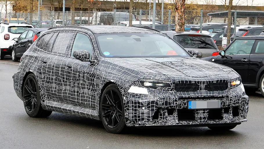 Blick von schräg vorne auf den fahrenden Erlkönig des BMW M5 Touring Facelift (2027).