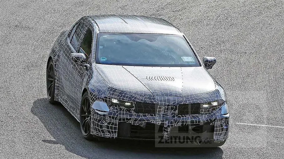 Der BMW i3 M (2027) fährt als Erlkönig auf einer Rennstrecke, von vorne fotografiert.