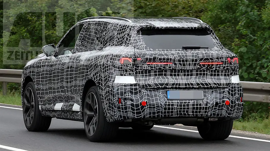 Der BMW X5 als Prototyp fahrend von schräg hinten fotografiert.