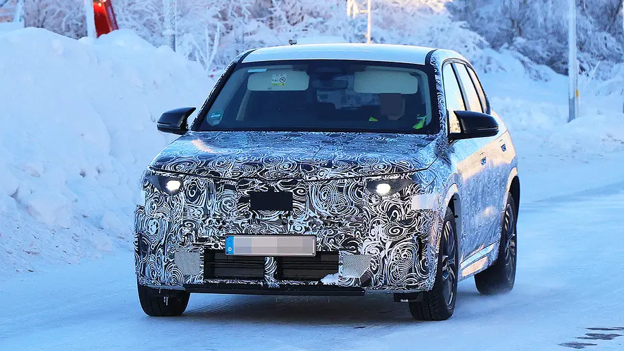 Blick von schräg vorne auf den fahrenden Erlkönig des BMW X1 Facelift (2026).