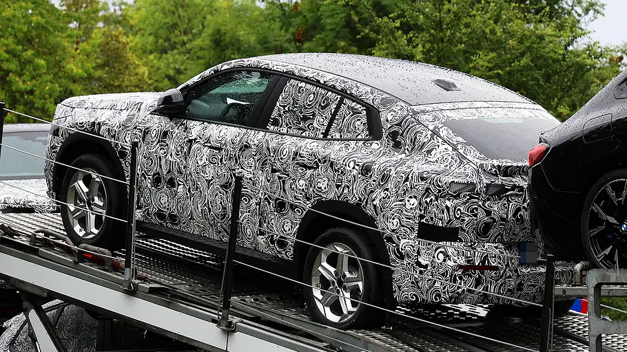 BMW X2 Facelift (2026) Blick von schräg hinten auf den Erlkönig des BMW X2 Facelift (2026), der auf einem Autotransporter steht.