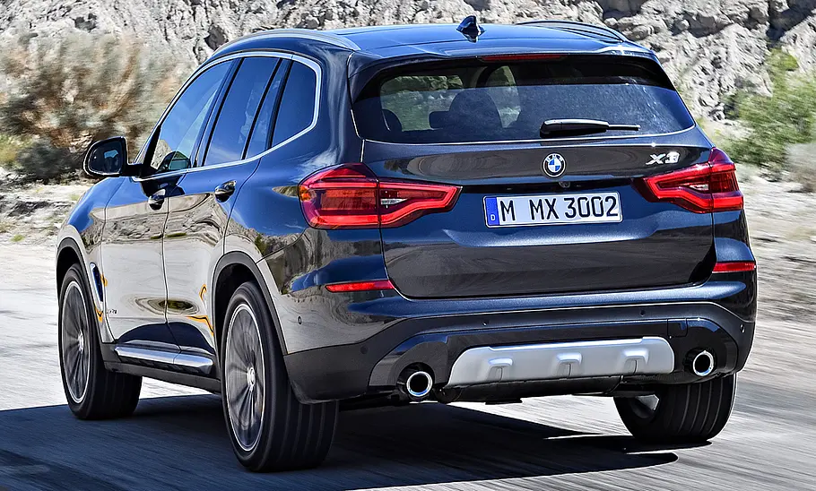 Der BMW X3 (2017) fährt eine Straße entlang, von hinten links fotografiert.