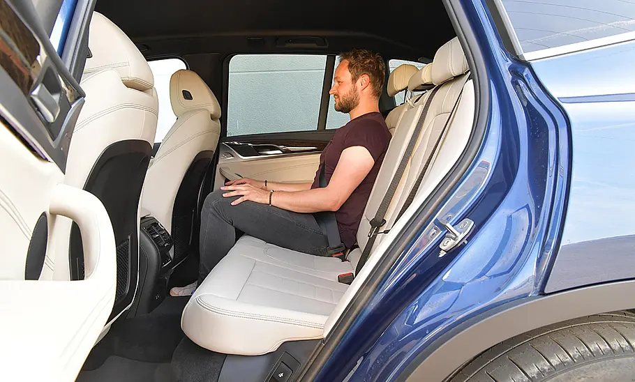 Ein Mann sitzt im Fond des BMW X3 (2017).