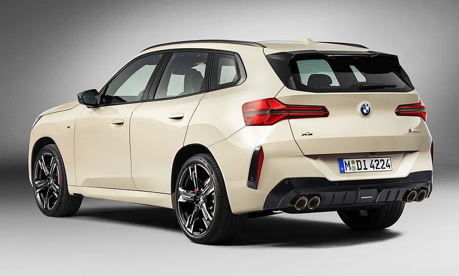 Der BMW X3 M50 xDrive (2024) steht in Studioumgebung, von hinten links fotografiert.