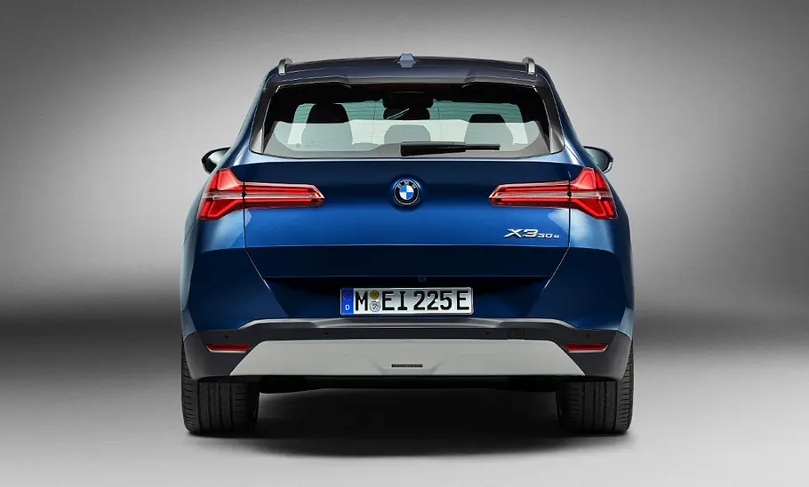 Der BMW X3 (2024) steht in Studioumgebung, von hinten fotografiert.