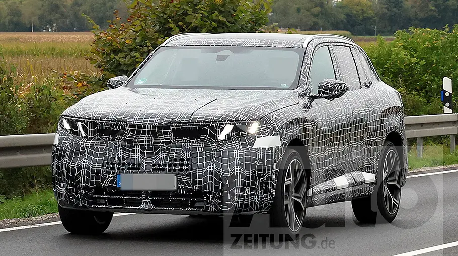 BMW (i)X5 (2026) Der BMW X5 (2026) fährt als Erlkönig auf einer Landstraße, von vorne links fotografiert.