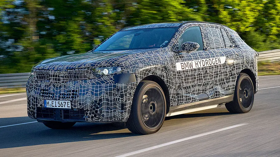 BMW (i)X5 (2026) Der BMW iX5 Hydrogen (2028) fährt als Erlkönig auf einer Straße, von vorne links fotografiert.