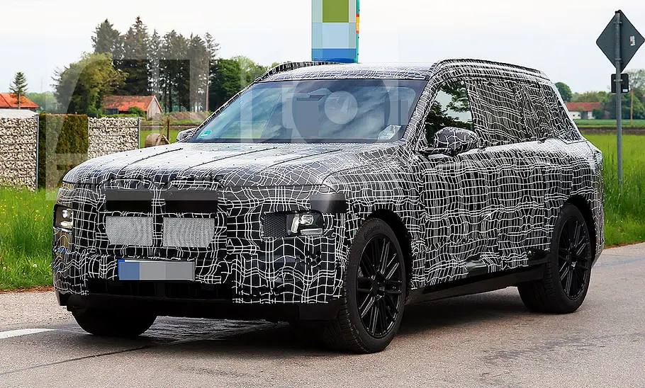 BMW X7 (2027) Blick von schräg vorne auf den fahrenden BMW X7 (2027).