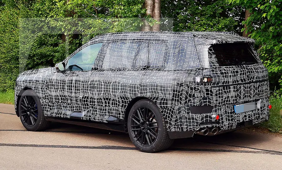 BMW X7 (2027) Blick von schräg hinten auf den fahrenden BMW X7 (2027).