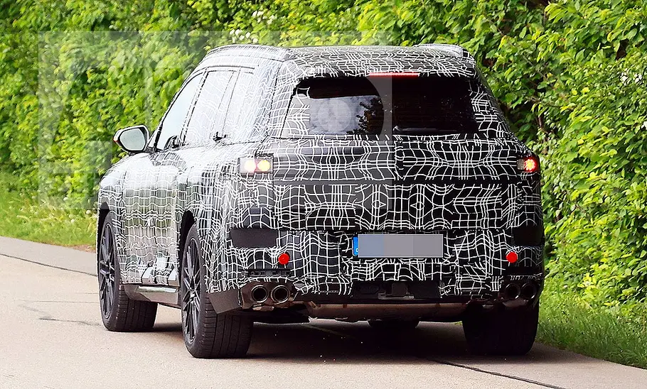 BMW X7 (2027) Blick von hinten auf den fahrenden BMW X7 (2027).