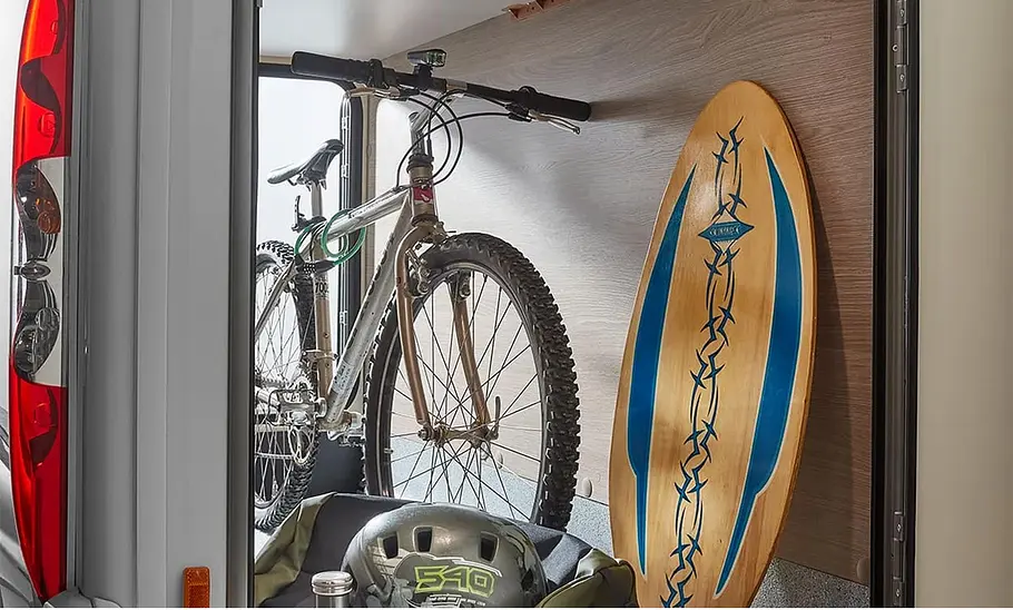 Bürstner Lineo T 690 G (2024): Das Foto zeigt die Heckgarage mit Fahrrad und Surfboard.