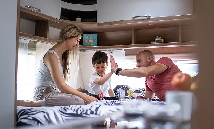 Bürstner Premio Plus (2025) Die Innenaufnahme zeigt eine Familie auf dem Hubbett des Bürstner Premio Plus (2025).