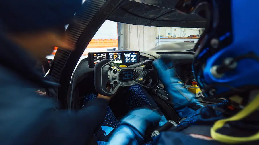 Bugatti Bolide Ein Mann zeigt dem Fahrer im Cockpit des Bugatti Bolide eine Funktion.