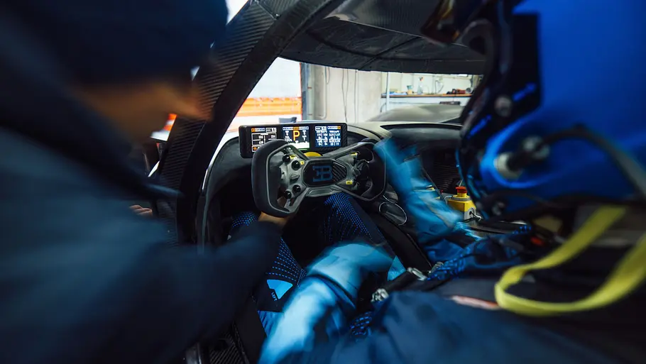 Bugatti Bolide Ein Mann zeigt dem Fahrer im Cockpit des Bugatti Bolide eine Funktion.