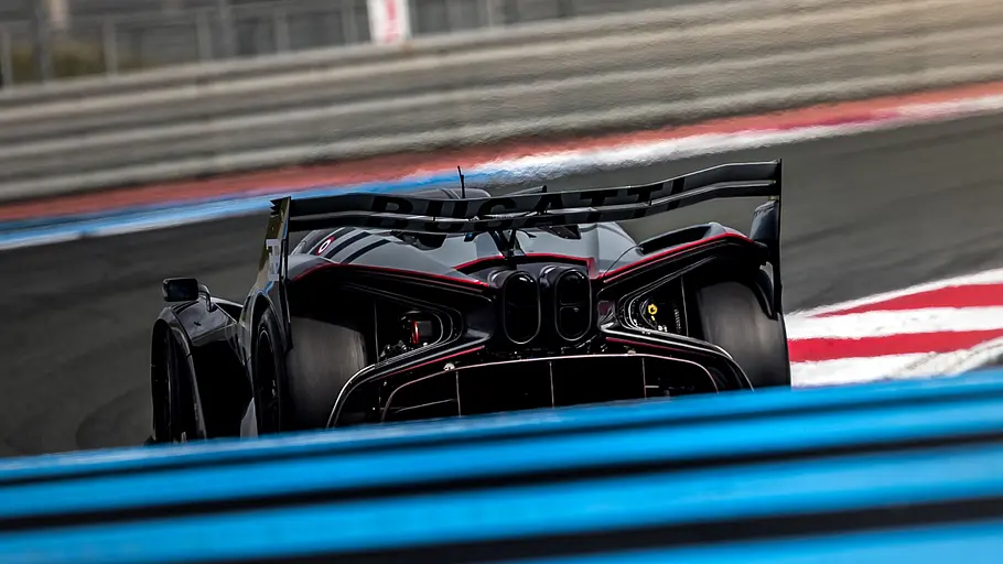 Bugatti Bolide Der Bugatti Bolide fährt auf einer Rennstrecke durch eine Rechtskurve, von hinten fotografiert.