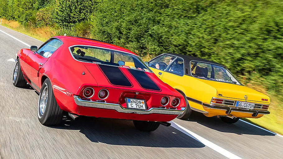 Chevrolet Camaro und Opel Commodore B GS fahrend von schräg hinten.