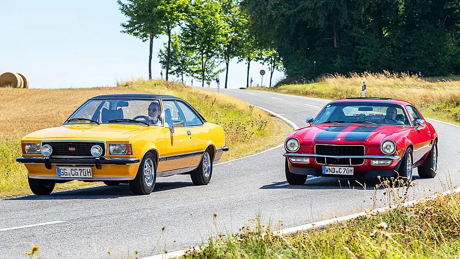 Opel Commodore B GS und Chevrolet Camaro fahrend von schräg vorne.