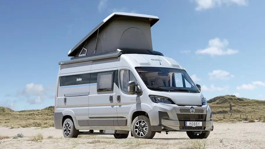 Campervans mit Aufstelldach Der Hobby Ontour Van statisch von schräg vorne rechts mit geöffnetem Aufstelldach am Strand.