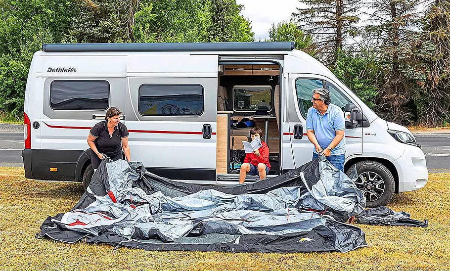 Tester beim Aufbau des dwt-Wohnmobil-Vorzelts, fotografiert am Wohnmobil.