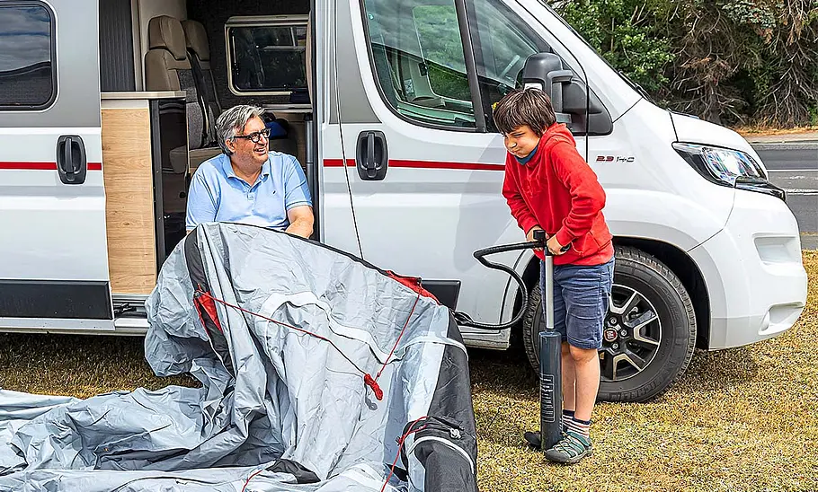 Tester beim Aufblasen des dwt-Wohnmobil-Vorzelts, fotografiert am Wohnmobil.