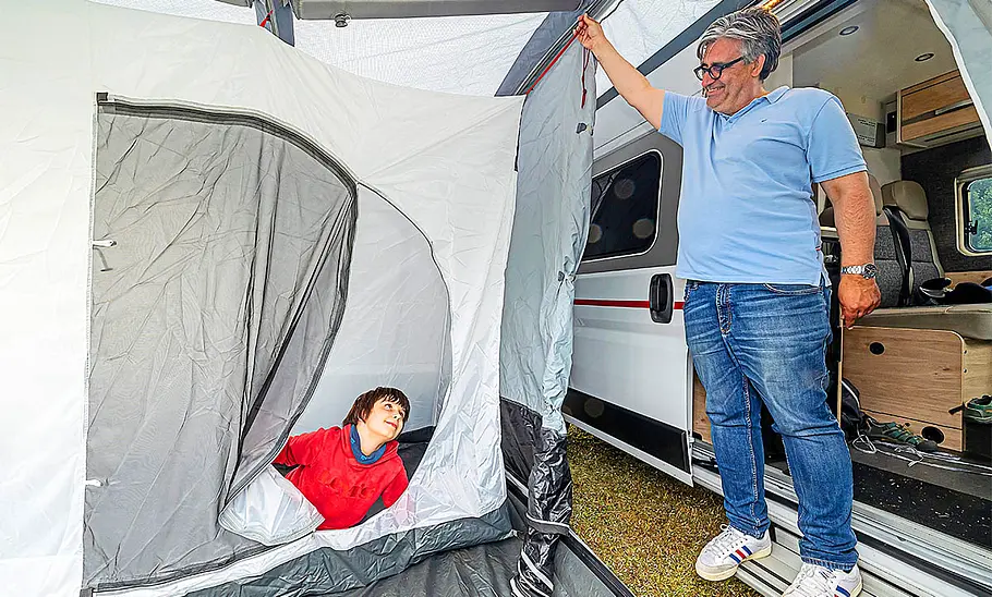 Tester im optionalen Schlafzelt des dwt-Wohnmobil-Vorzelts, fotografiert am Wohnmobil.
