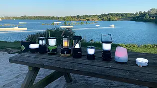 Überblick über die Testlampen im Campinglampen-Test. Die stehen auf einem Tisch nebeneinander. - Foto: AUTO ZEITUNG