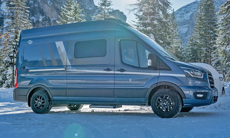 Der Carado CV590 4x4 ist mit Ansicht von schräg vorne fahrend im Schnee zu sehen.
