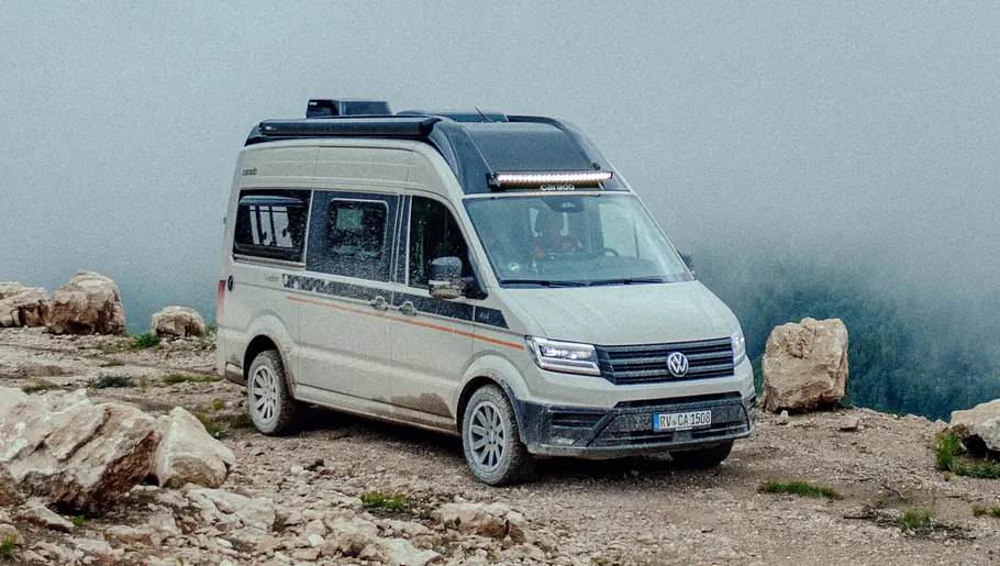 Der Carado CV595 X-Edition stehend von schräg vorne rechts vor einer Nebelwand an einer Klippe.