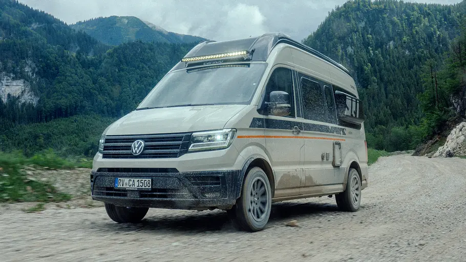 Der Carado CV595 X-Edition fahrend von schräg vorne links auf einer Schotterstraße in den Hochalpen.