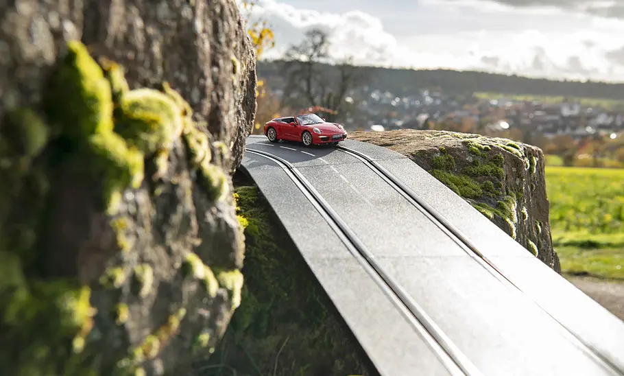 Der Carrera-Bahn Porsche 911 fährt durch die Natur.