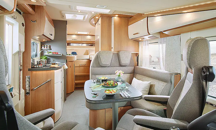 Der Innenraum des Carthago C1-Tourer (2024) mit Blick auf die Dinette und die Küche.